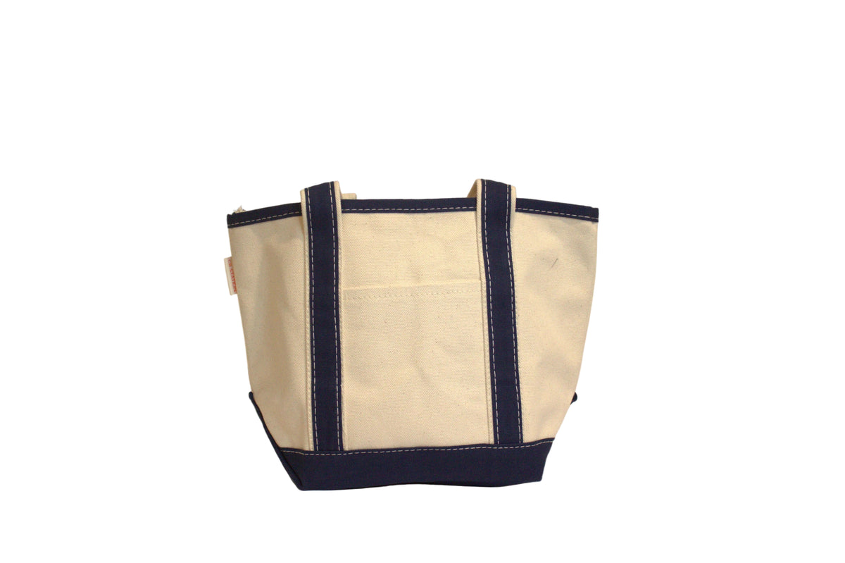 Beige tote bag with navy blue trim on a beige background